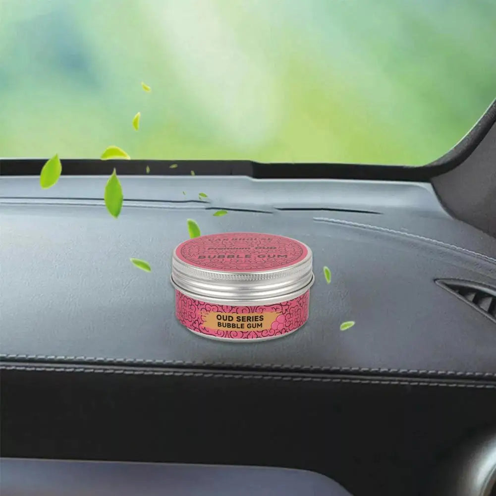 high-end car air freshener in a stylish tin on a car dashboard with green leaves indicating freshness